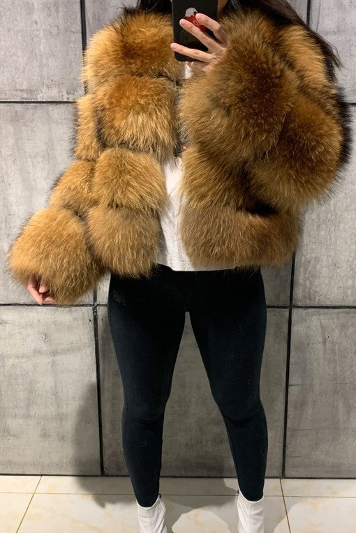 Person wearing a brown fur coat against a tiled wall.