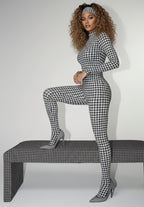 Person wearing a black and white checkered outfit sitting on a matching bench.