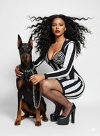 Woman in a black and white dress with a Doberman on a white background