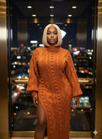 Woman wearing an orange cable knit dress with a blurred cityscape background