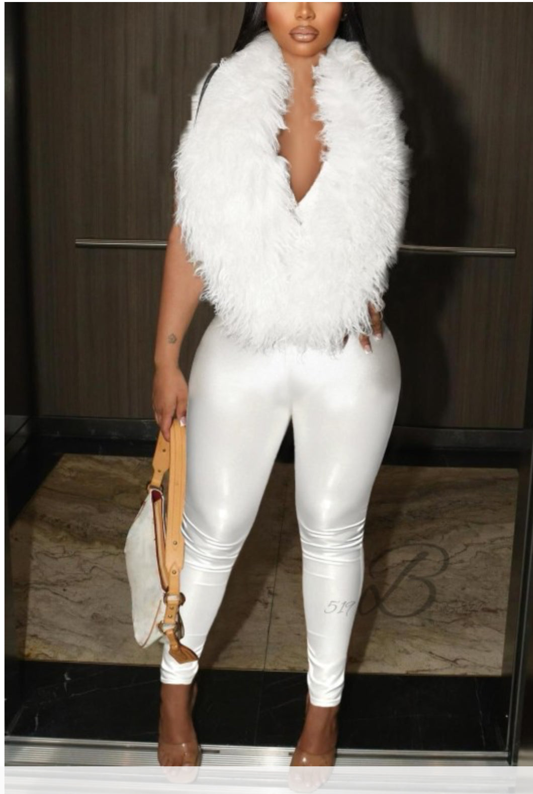 Person wearing a white outfit with a feathered accessory in an indoor setting