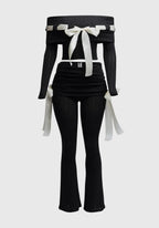 Black outfit with white ribbons on a light gray background