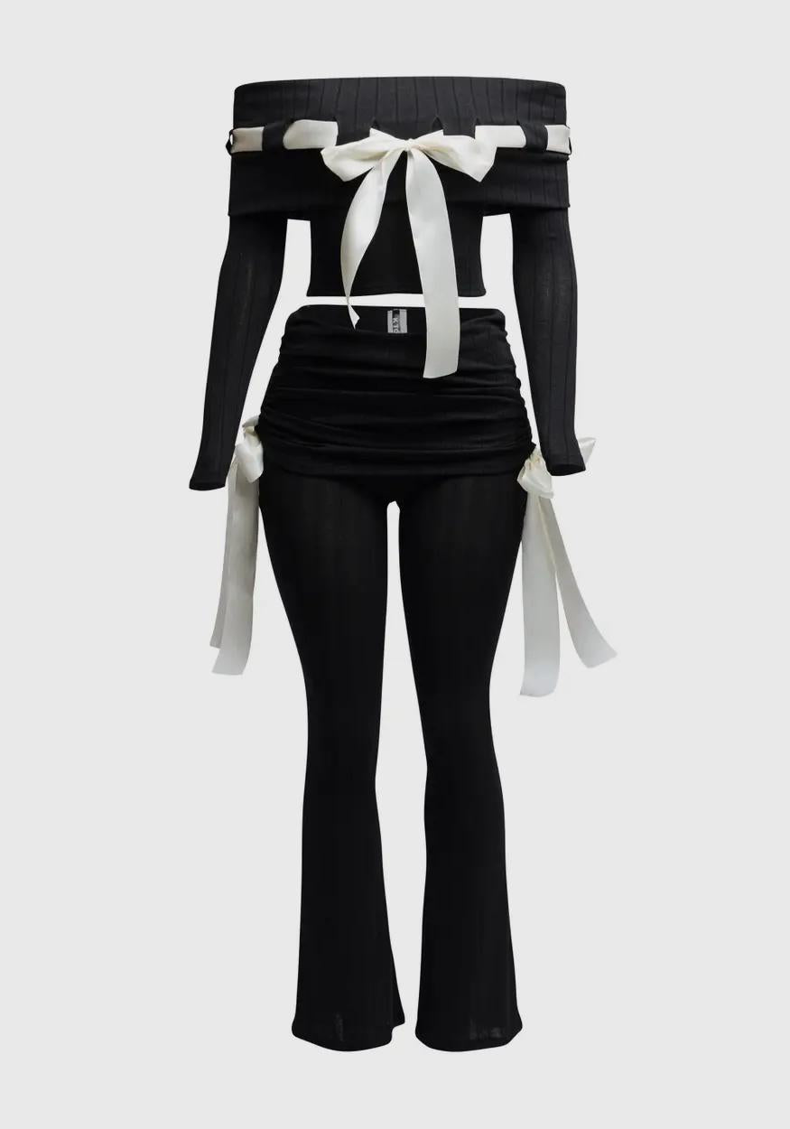 Black outfit with white ribbons on a light gray background