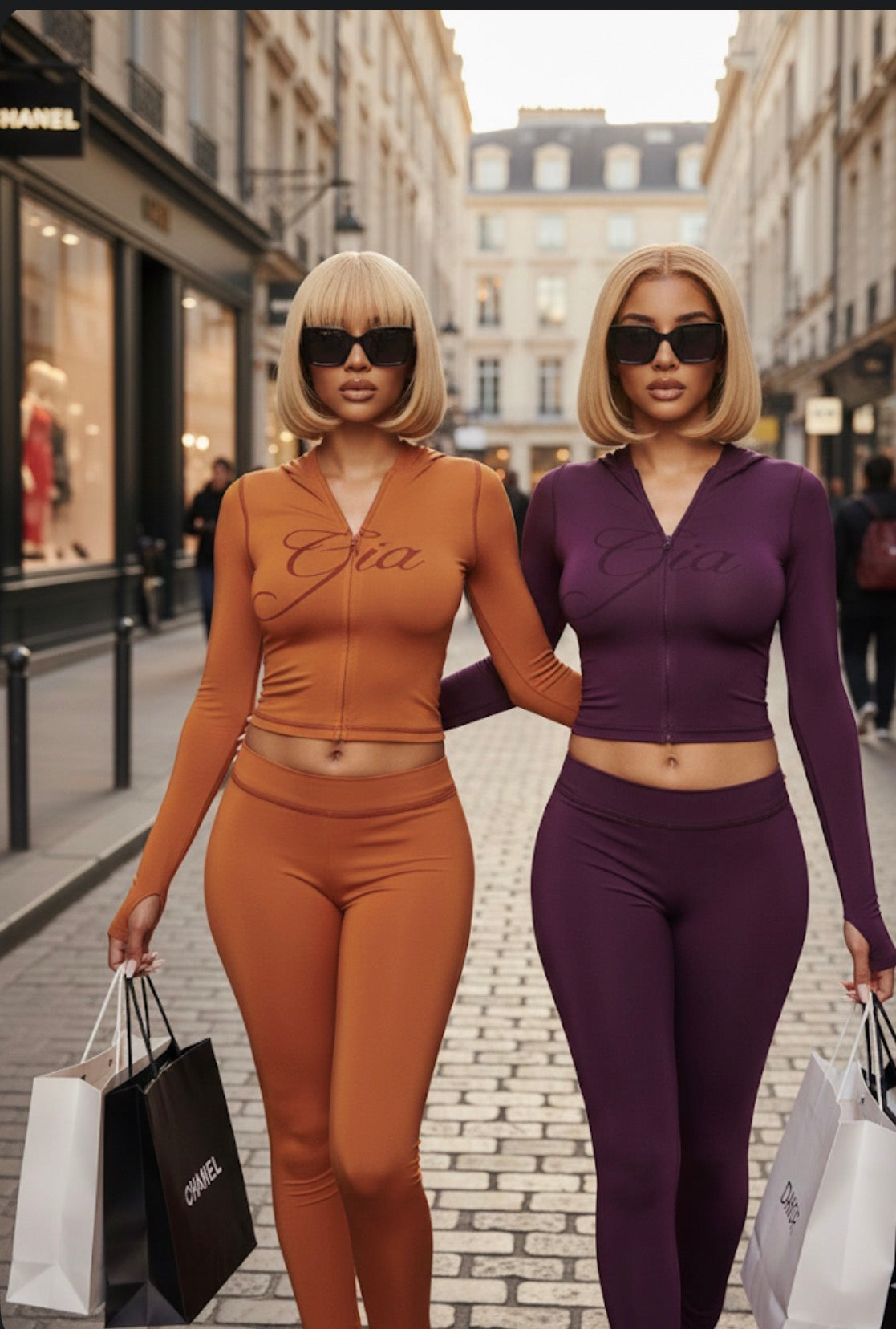 Two women in matching outfits with shopping bags on a city street.