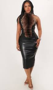 Woman wearing a black leather dress with fur trim on a white background